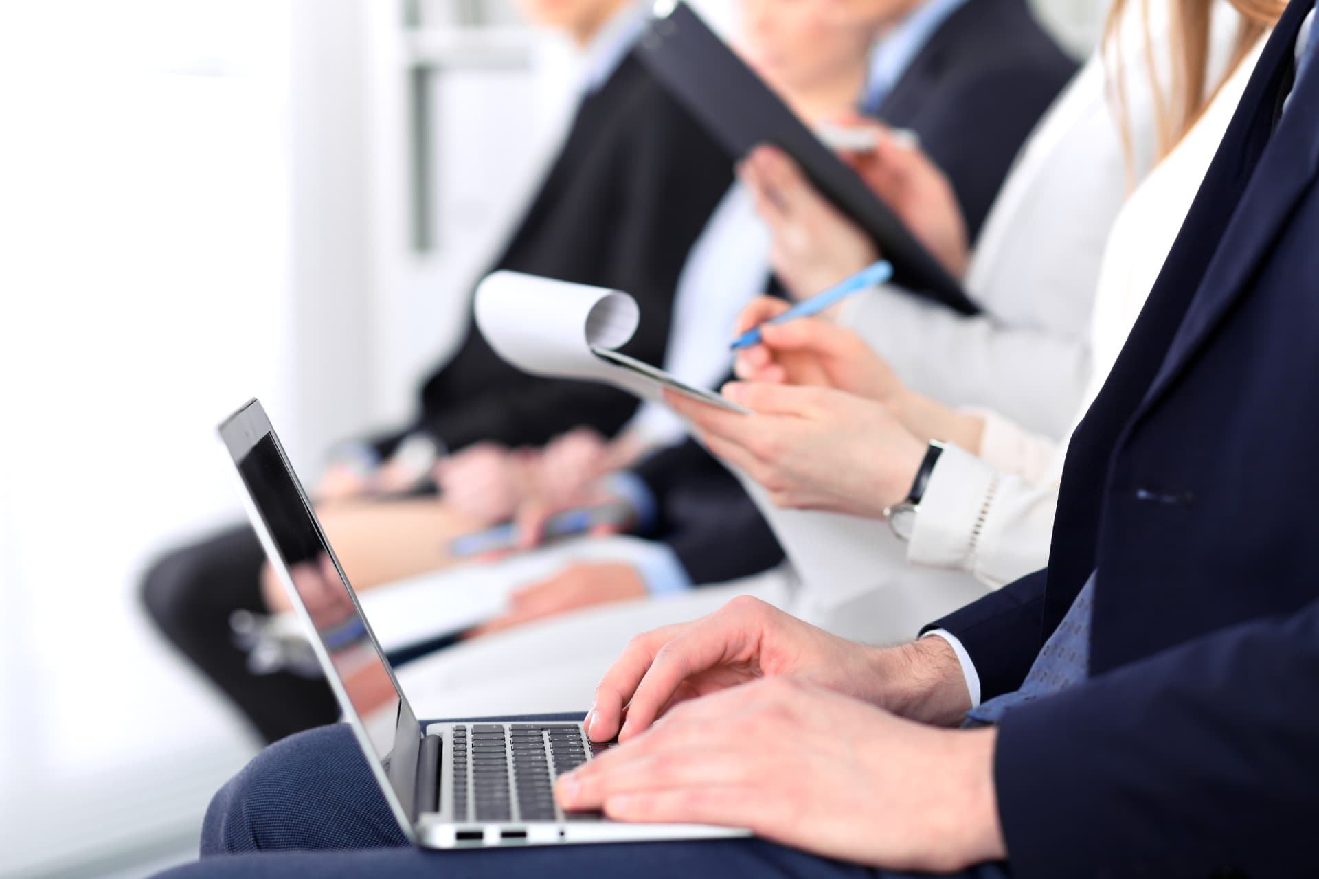 Seminerde not alan ve dizüstü bilgisayar kullanan katılımcılar
